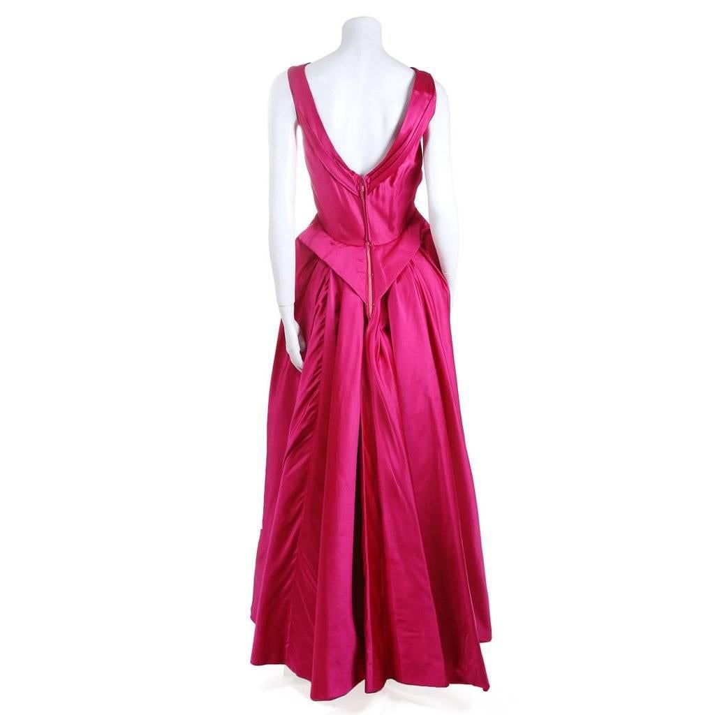 Fuchsia silk satin sleeveless ballgown, draped bodice detailing on front bust, pleated and gathered for V-shaped back, full stiffened floor length skirt, metal zip closure up the center back. 