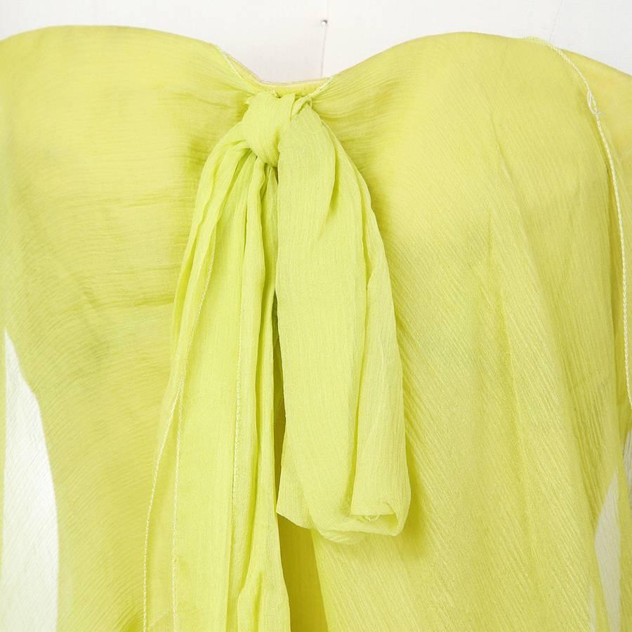 This is a Thierry Mugler floor length gown gown circa 1980s.  It's made of a lime green silk chiffon, strapless, and features a front tie knot.  The two drapes over bust continue around the back to create a halo effect.  