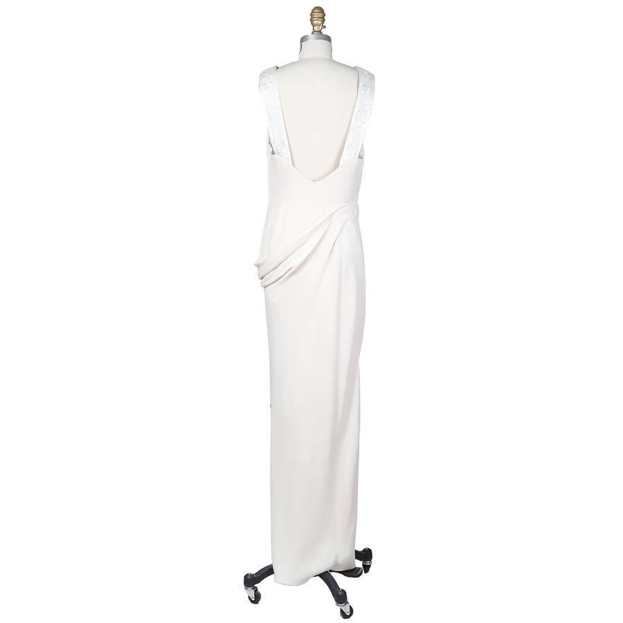 This is a 1992 couture gown from Valentino.  It is a creamy soft pink color and features an asymmetrical drape at the waist. The back straps are white satin embellished with a beaded and embroidered pattern.  Hidden side zipper with hook and eye