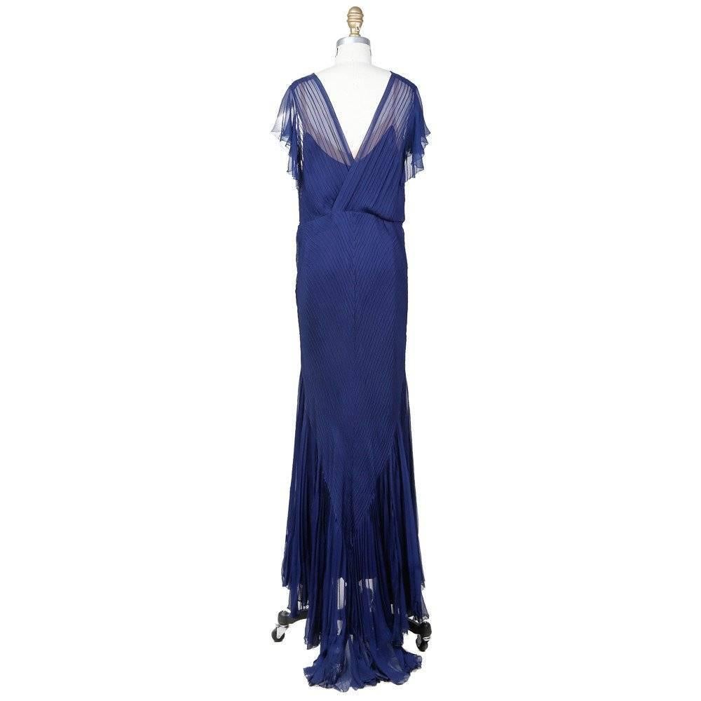 This is an indigo blue silk chiffon gown with attached slip. The cap sleeves are slightly ruffled to create a delicate drape over the shoulder.  The slip has a nude trim and straps, as well as a scalloped hem.  The outer chiffon uses cross hatch