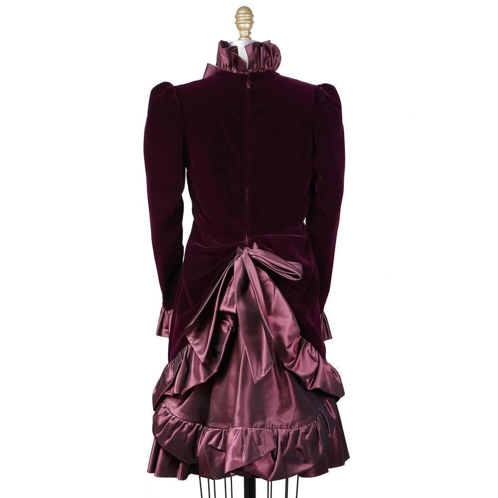 This is an haute couture dress from Yves Saint Laurent c. 1980s.  It is made from a plum colored satin and a shimmering mauve satin.  It features ruffled cuffs and a high ruffled collar, as well as a curved two tier ruffled skirt.  Other details