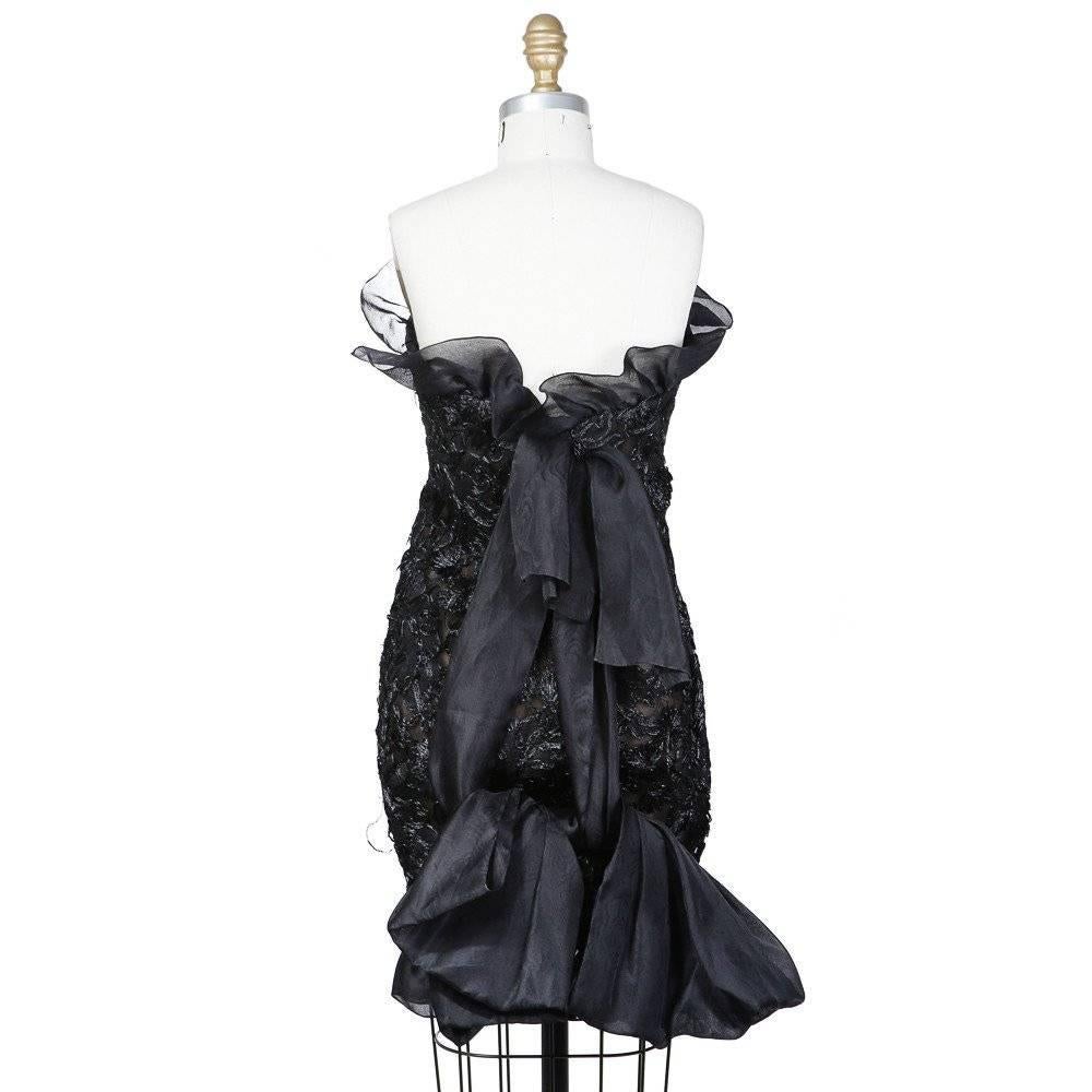 This is a black haute couture cocktail dress by Yves Saint Laurent c. 1980s.  The body is a fine mesh embroidered with black straw to create a floral motif.  It is also lined a brown chiffon and structured support for the bodice.  Other details