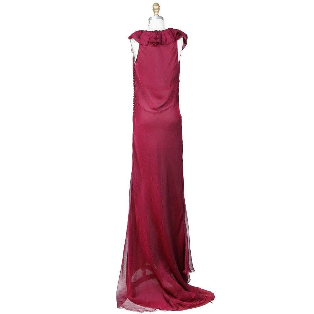 This is a sleeveless floor length dress designed by Oscar De La Renta for Balmain c. 1990s.  It is made from plum colored silk chiffon and features a scooped neckline with a quadruple layered flounce trim that continues around the back.  Some other