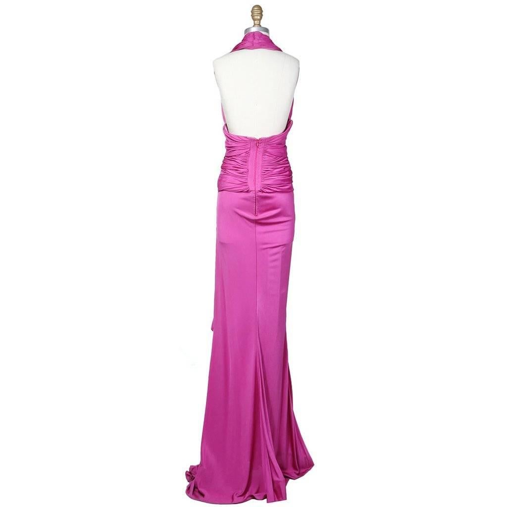 This is a strapless evening gown by Jean-Louis Scherrer c. 1950s.  It is made from a fuchsia colored satin jersey.  It features a classic halter neckline, draped fabric in the back that circles to the front in pedaled layers, and a goddess draped