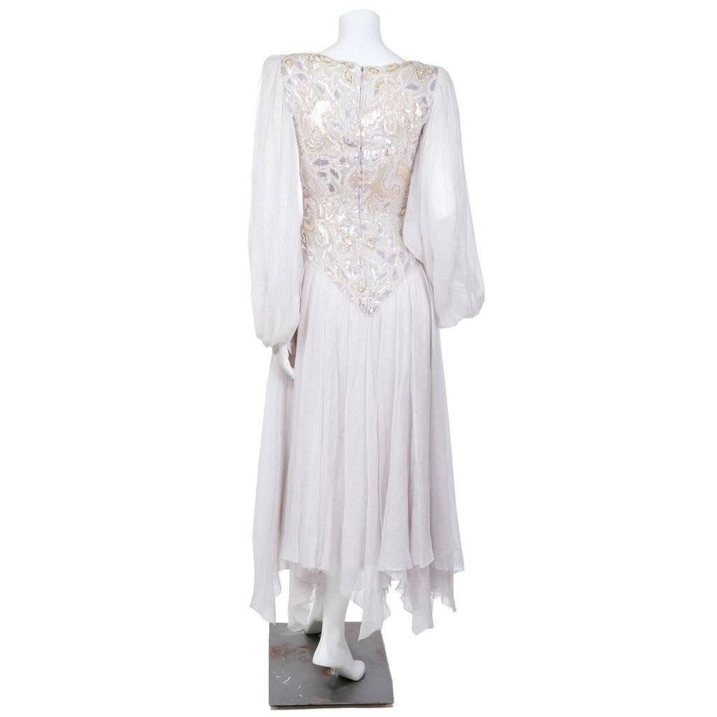 This is a dress by Jean Louis Scherrer c. 1980s.  It features a bodice that is ornamented with design of beads and paillettes. The skirt is a triple layer of shimmering chiffon while the peasant sleeves are a single layer of the chiffon for more