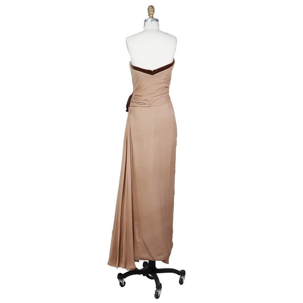 This is an haute couture floor length strapless evening gown from Jean Dessès c. 1950s.  It is made from a mocha colored silk chiffon with a darker brown velvet trim along neckline and bow at the side of the waist.  The fabric gathers where the bow