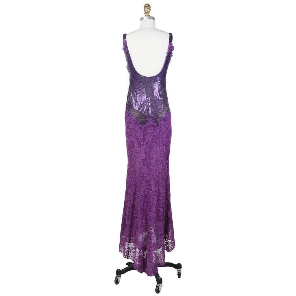This is a floor length gown by Versace Atelier c. 1980s.  It features a metallic purple mesh bodice and a purple lace mermaid shaped skirt.  The skirt has a purple chiffon slip lining and the bodice is padded and lined with purple satin.  The