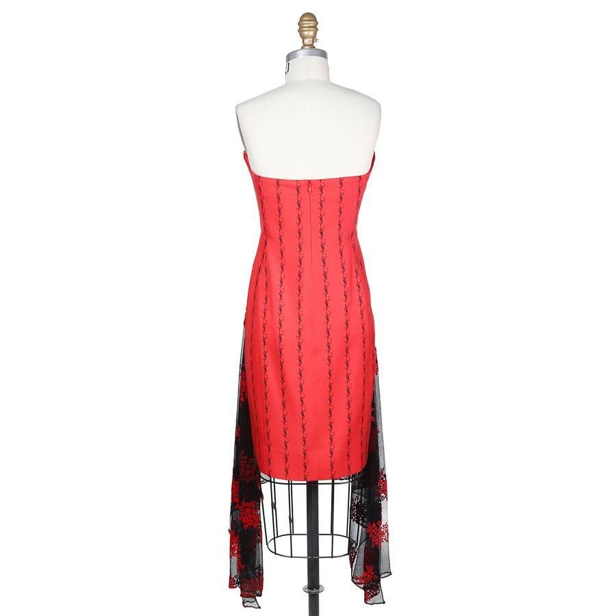This is a strapless dress by Yves Saint Laurent c. 1980s.  It features the YSL monogram in columns to create a vertical stripe effect.  Another detail is the attached mesh overlay that that drapes over the front of the dress, which has a patterned