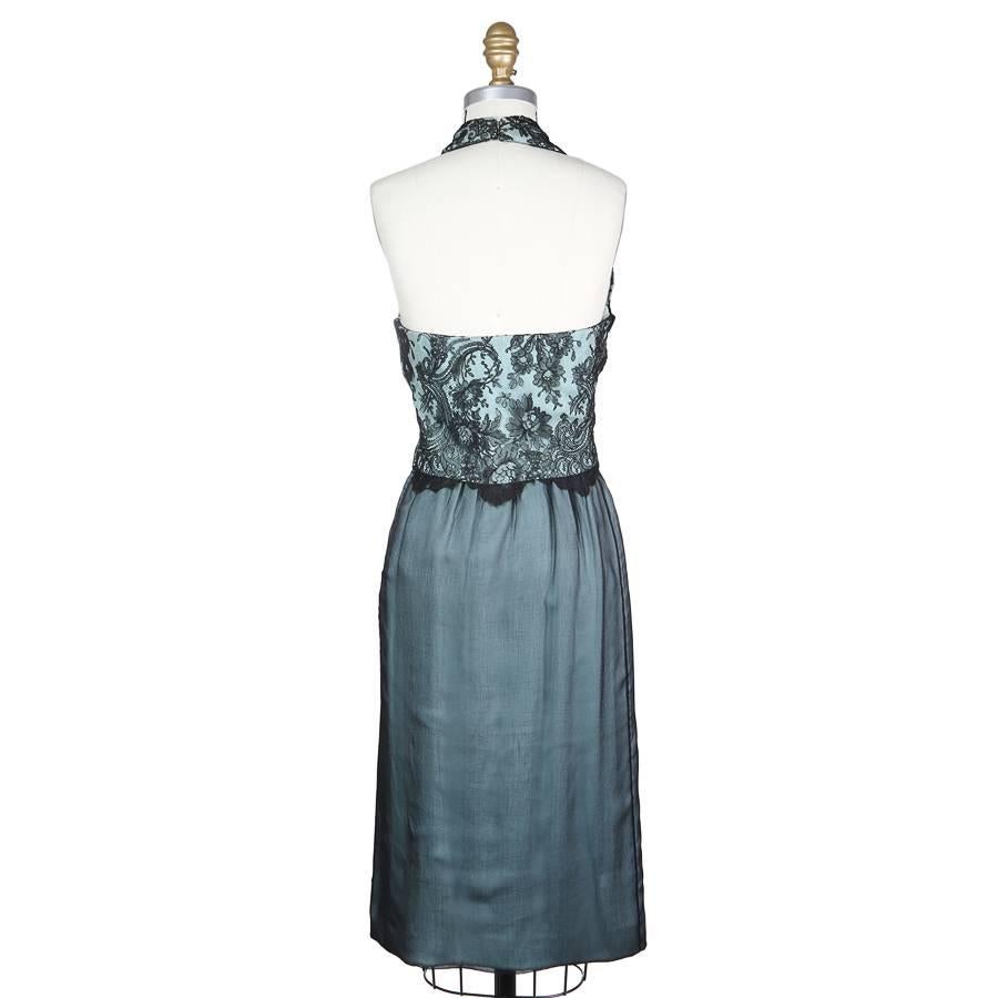 This is a halter style cocktail dress by Pierre Balmain c. 1960s.  It is an aqua color with a black lace overlay for the bodice and a dark sheer chiffon for the skirt.  Another detail is the attached front bow at the waist.  The dress includes a