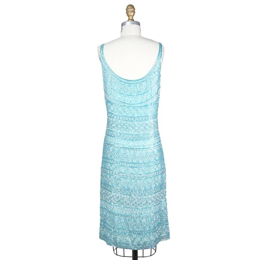 This is a turquoise beaded sleeveless dress by Halston c. 1980s.  It features an intricate beaded design that has multiple motifs in rows along the entire dress, including the straps.  This gives an illusion of subtle stripes from far away.  The