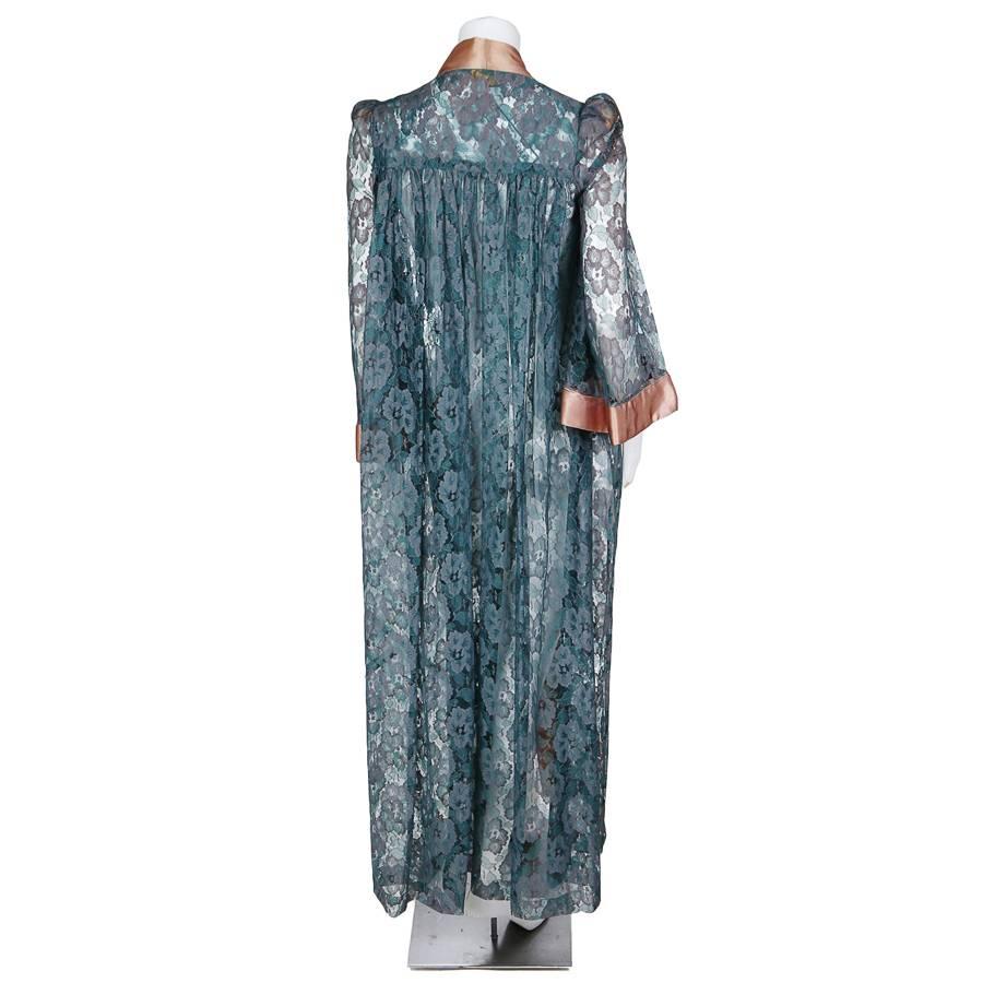 This is a long jacket with 3/4 bell sleeves by Biba c. 1970s.  It features a predominantly teal colored lace with some accents of mauve.  The coat uses a copper satin trim for the sleeve cuffs and the collar.  The shoulder to shoulder measurement is