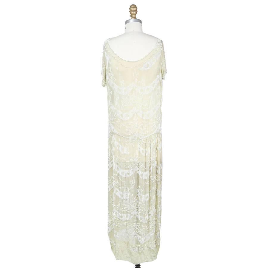 This is a light mint colored chiffon shift dress c. 1930s.  The designer is unknown due to the lack of tag and age of the dress.  All around the dress is decorated with a floral design made from tiny white beads.  There is no closure so the dress