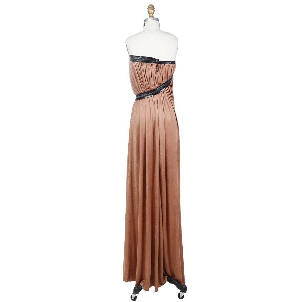This is a Strapless Gathered Zipper Dress by Jean Paul Gaultier circa 1980s. Details include patent leather trim on zipper, zipper wraps around body giving shape to the waist, and silver hardware. Closures include a zipper up center back. 