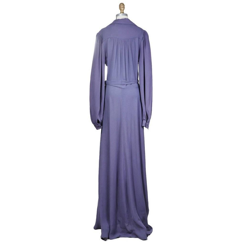 This a long sleeve floor length iris colored crepe dress by Ossie Clark c. 1970s.  It features bishop style sleeves, lapel collar, and buttons down the center front.  The top also has piped seams down the front.  