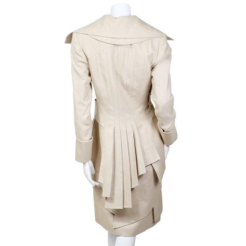 This a beige colored celadon linen haute couture coat by Alexander McQueen for Givenchy c. late 1990s.  This coat features tiered layers, including part of the exaggerated lapel collar, to give a cascading effect.  The back features an asymmetrical