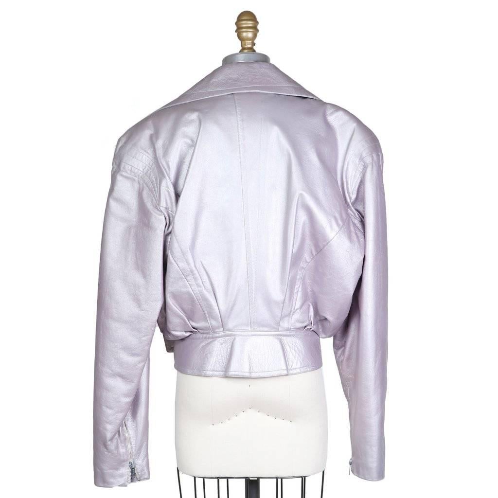 This is a shimmering lilac colored leather motorcycle by Thierry Mugler c. 1980s.      It features silver hardware, two side waist zippered pockets hidden in the front seams, and a belted waist at the hem. Other details include an over sized