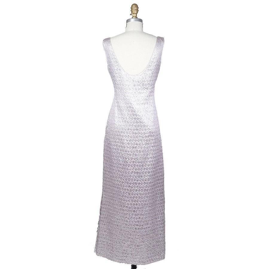 This is a sleeveless high waisted dress by James Galanos c. 1970s.  It's made from a shimmering lavender colored brocade fabric with a textured pattern.  The closure is a zip up the center back.