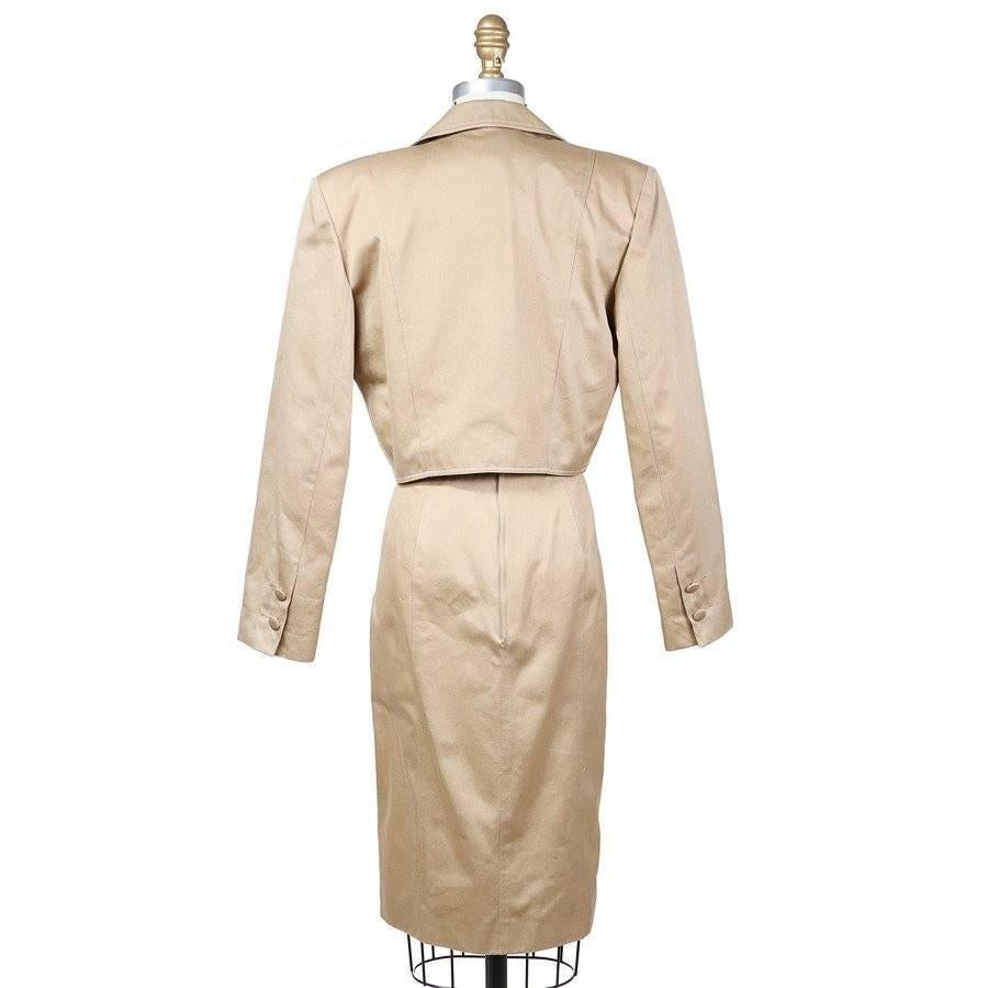 This is a beige strapless dress and jacket set by Patrick Kelly c. 1980s.  The dress features a corset with shoe string lacing, a sweetheart neckline, and a v shaped seam at the waist.  The cropped jacket has a matching lace up detailing, a lapel