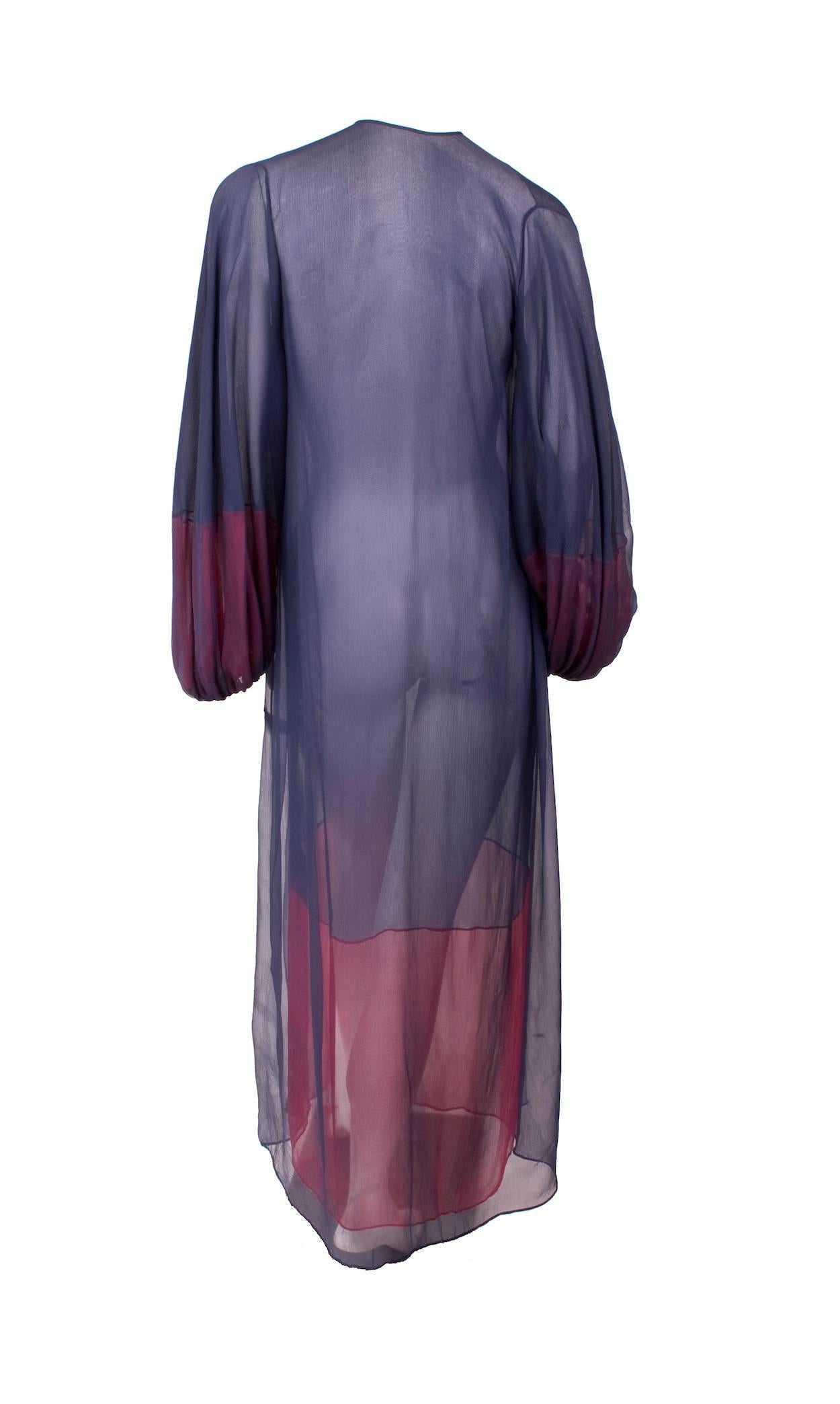 This is a double layered silk chiffon caftan by James Galanos c. 1970s.  It's made primarily from navy chiffon with under layered red chiffon accents and features bishop style sleeves.  The under chiffon layer closes with 3 buttons in front and a