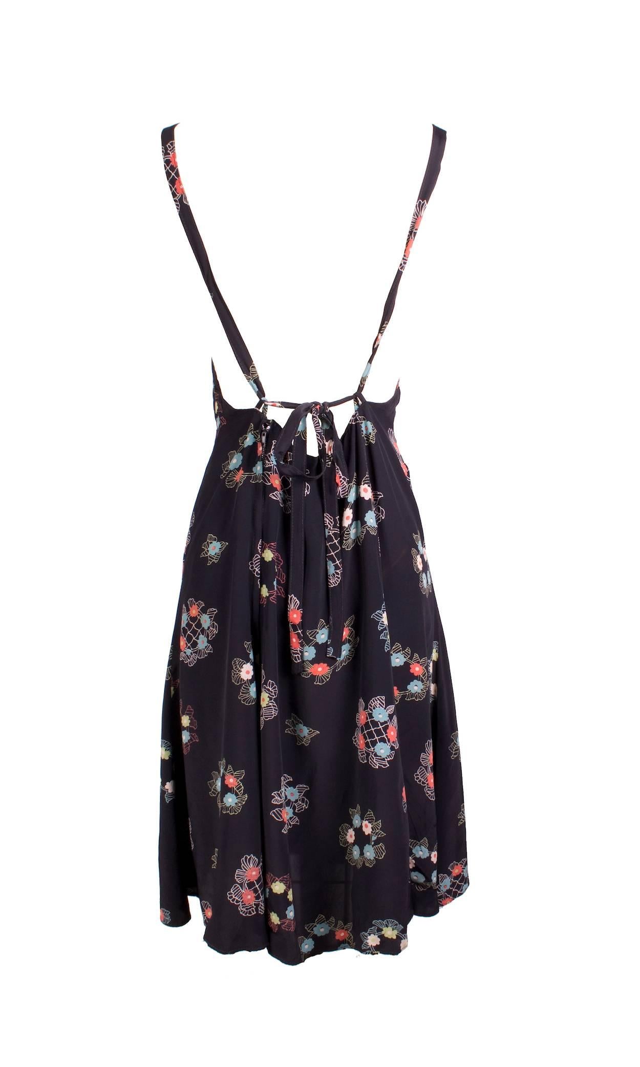 This is a silk chiffon dress by Ossie Clark c. 1970s.  It features a floral print by Celia Birtwell. Details include halter straps and a cinching back tie. There is also a hidden zipper down the center back.  