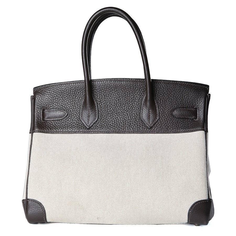 This is a 30cm square Birkin bag by Hermes from 2005.  It is made from dark brown clemency leather and a beige canvas. It features silver palladium hardware.
Length 11.5"
Width is 6.5"
Height is 9"
