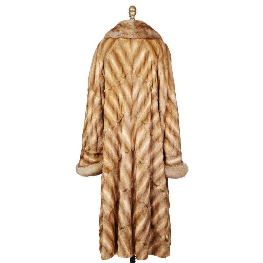 This is a recent long tan mink coat by Fendi.  It features a large rounded collar and roll up cuffs.  The closure is a single button at the collar and a hook and eye over the bust.  It also has a raglan sleeve and shoulder pads. 100% silk lining.
