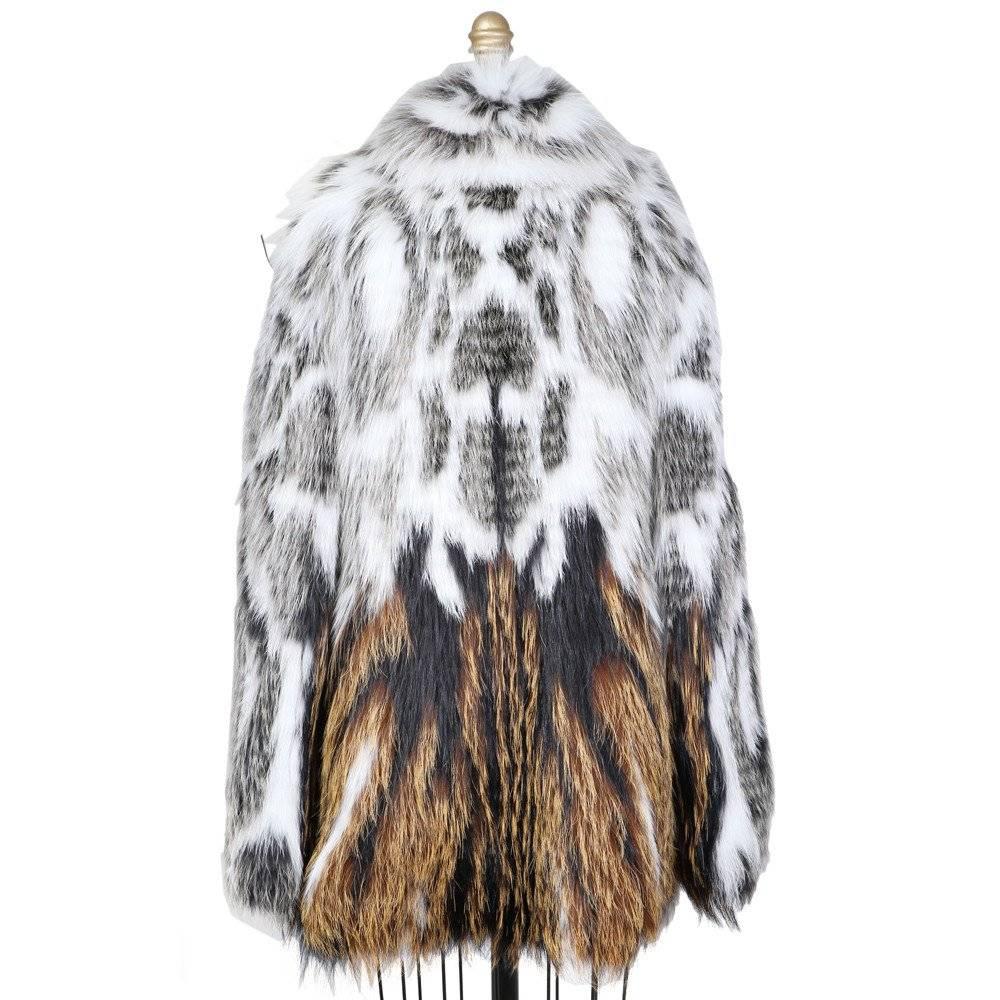 This is a current fox fur coat by Fendi.  It features silver fox and arctic fox furs.  Silk lined. The tag is still attached.  Retails now for $30,000.
Shoulder to shoulder measurement is 17"
Sleeve length is 26"