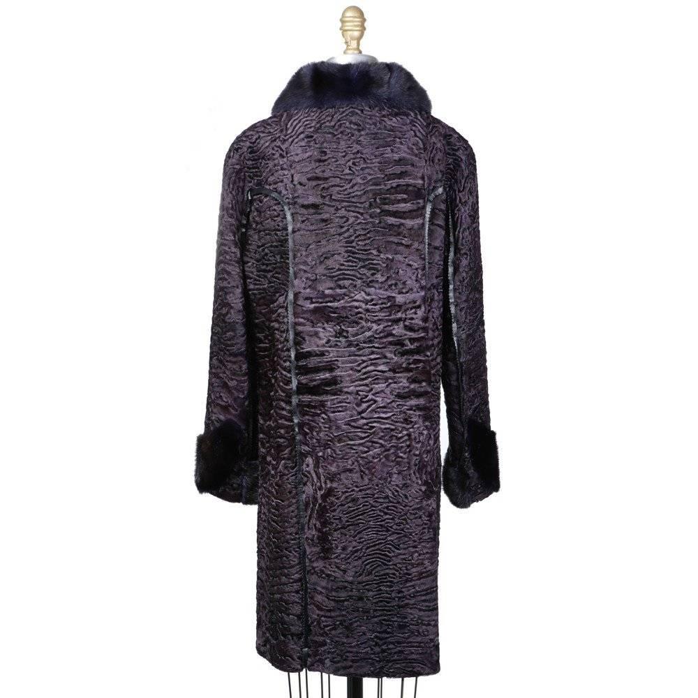 This is a recent long dark purple broadtail coat by Fendi.  It features leather trim around the seams, hidden waist pockets, and a black leather lining.  The sleeve is a raglan cut and the closures are hook and eyes down the front.