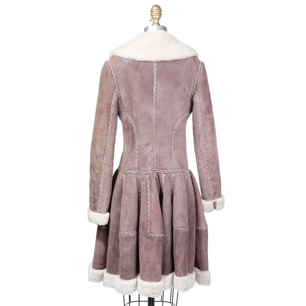 This is a suede shearling coat by Azzedine Alaia from the past 5-10 years.  It features interlocking curved cut detail on seams, long full skirt (cut like a circle skirt), and hidden string tie around waist.  It has a shearling lining, collar, and