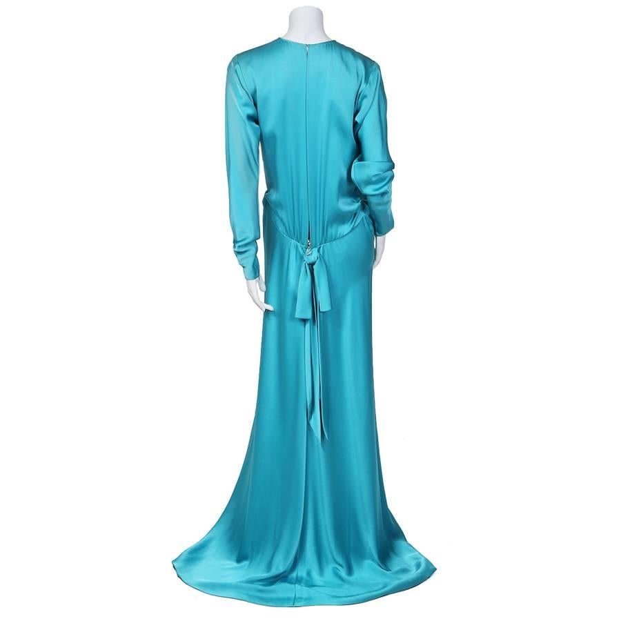 This is a turquoise silk gown by Yves Saint Laurent c.  It features long sleeves and a snap on back bow.  The closures are a back zipper below the waist, and top hook and eye closure.  Made in France.
Sleeve length is 29"
Shoulder to shoulder