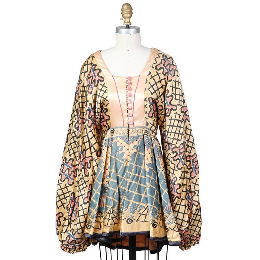 This is a peasant skirt and blouse by Zandra Rhodes c. 1970s.  It features a multicolor pattern on both pieces.  The blouse has bishop sleeves, silk button corset closure in front, and a peplum.  The skirt is accordion pleated. 

For the blouse: