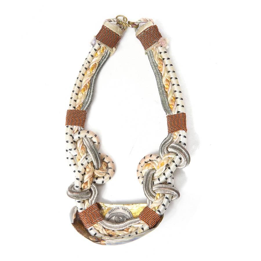 This is a choker crafted by Alex and Lee from the 1970s.  It features a multi roped chain bound by string wrapping with an iridescent shell ornamenting the front.  Alex and Lee were artists and renegade jewelers from the bohemian movement of the