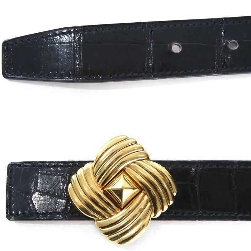 This is a black patent crocodile belt from Hermes from 1995. It features a gold buckle with a woven look pattern and a center stud with rounded edges.
Length is 34"
Width is 1"