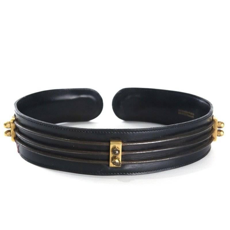 This is a black leather slip on belt from Hermes c. 1930s.  It features gold hardware, thin bronze rods creating structure, leather backing, and has open gap in center front.
Length is 25"
Width is 2"