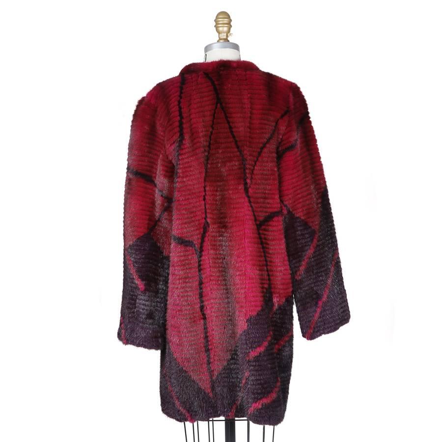 This is a contemporary coat by Oscar De La Renta.  It is made from magenta and orchid dyed LH mink in an abstract geometric design.  It is silk lined and features snap closures in front and a large overlapping crossover collar.
Shoulder to shoulder