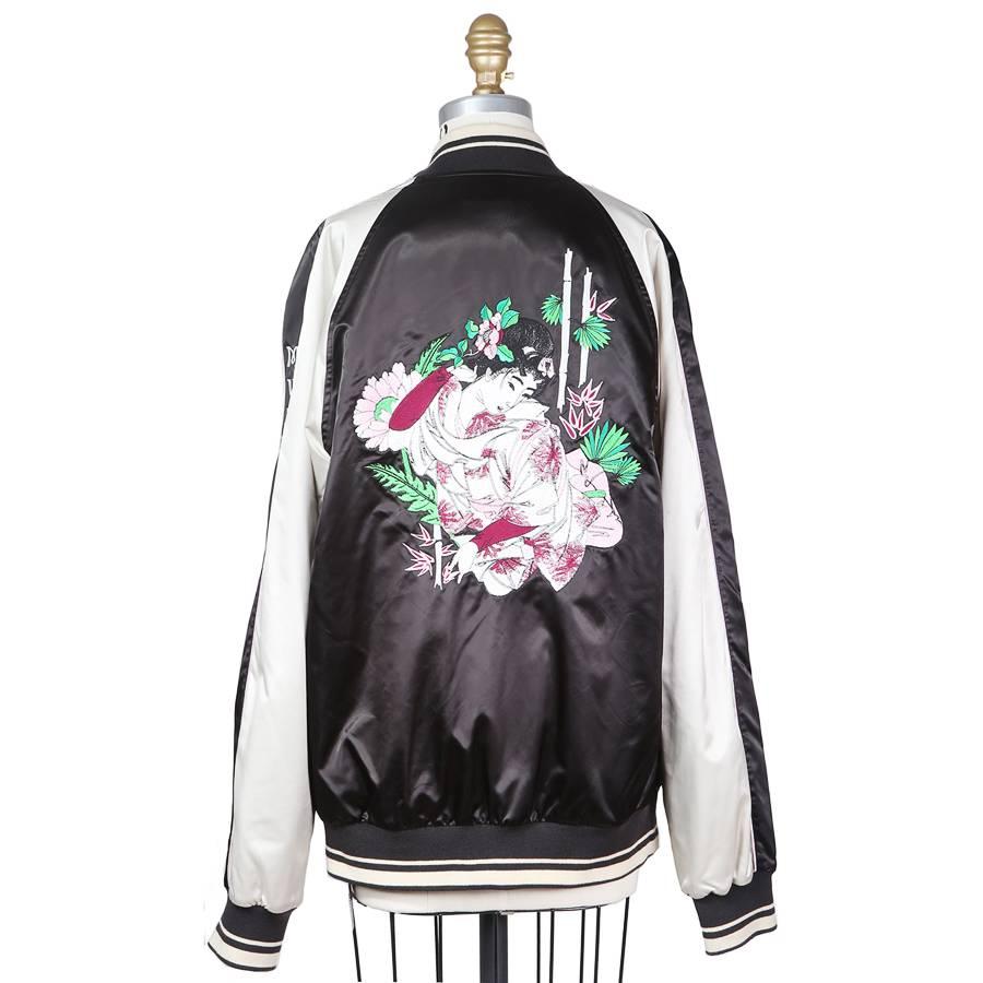 This is a contemporary souvenir jacket by Dolce and Gabbana. It features a floral Japanese motif embroidered on the front chest and on the back.  It has a raglan sleeve/shoulder, one inside breast pocket, and two outer waist pockets. Made in Italy.
