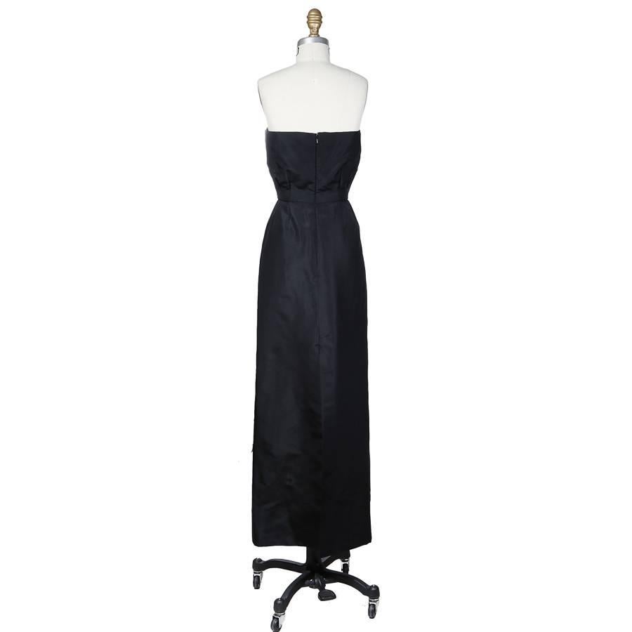 This is a strapless haute couture sheath dress by Christian Dior c. 1980s.  It is made from black taffeta and features a sweetheart neckline and defined waist.