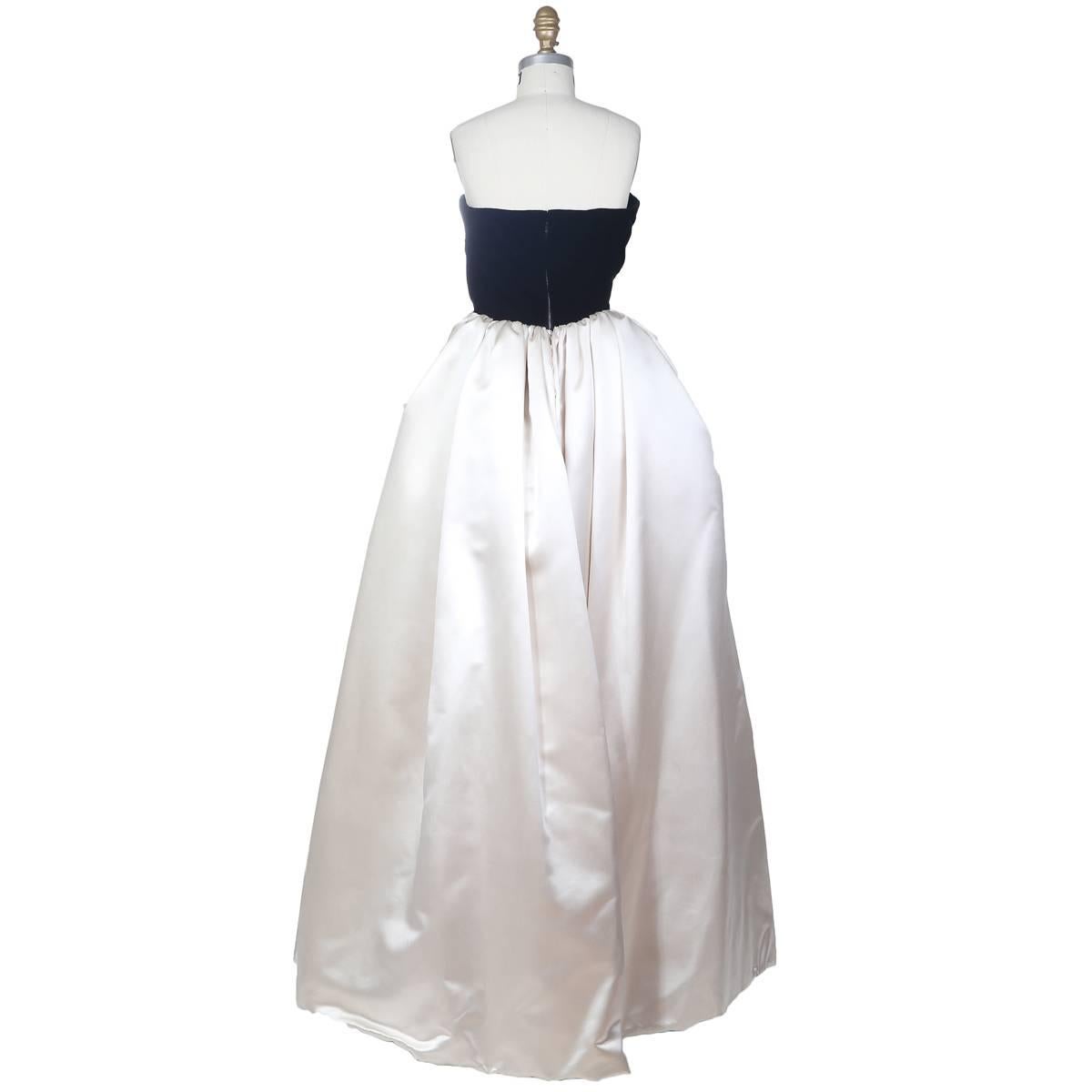 This is a strapless ball gown by Mila Shon c. 1980s. It features a velvet bust with polka dot tulle draped over it and the skirt is in white silk.