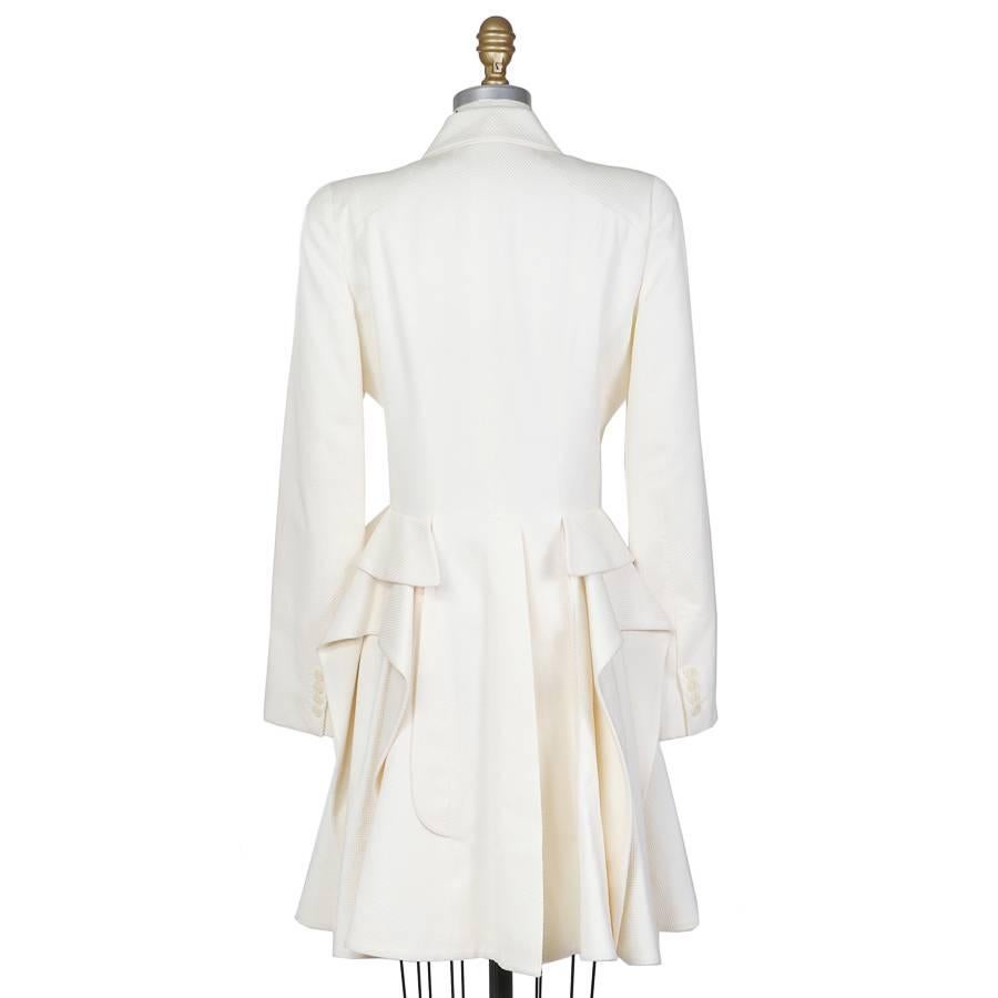 This is a jacket by Sarah Burton for Alexander McQueen from the resort/pre-spring 2011 collection. It is made from a cream colored pique fabric and features a double breasted front closure and cascading peplum to create a samurai skirt effect.  This