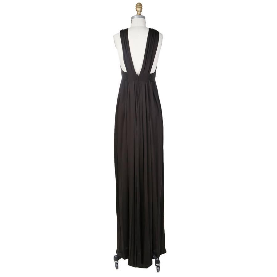 This is a black jersey goddess style dress by Tom Ford for Gucci from the early 2000s.  It features a halter style neckline and pleating from the neckline to the bottom hem.  The closure is a zipper on the back inside hidden by a top layer with hook