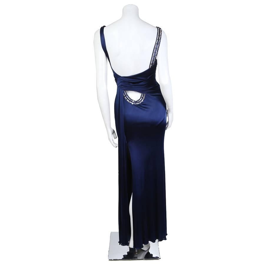 This is a navy blue silk jersey dress by Donatella Versace from her fall 2009 collection.  It features a deco style metal detail on one shoulder that curves and continues to the back, ending at the waist.  The closure is an invisible side zipper
