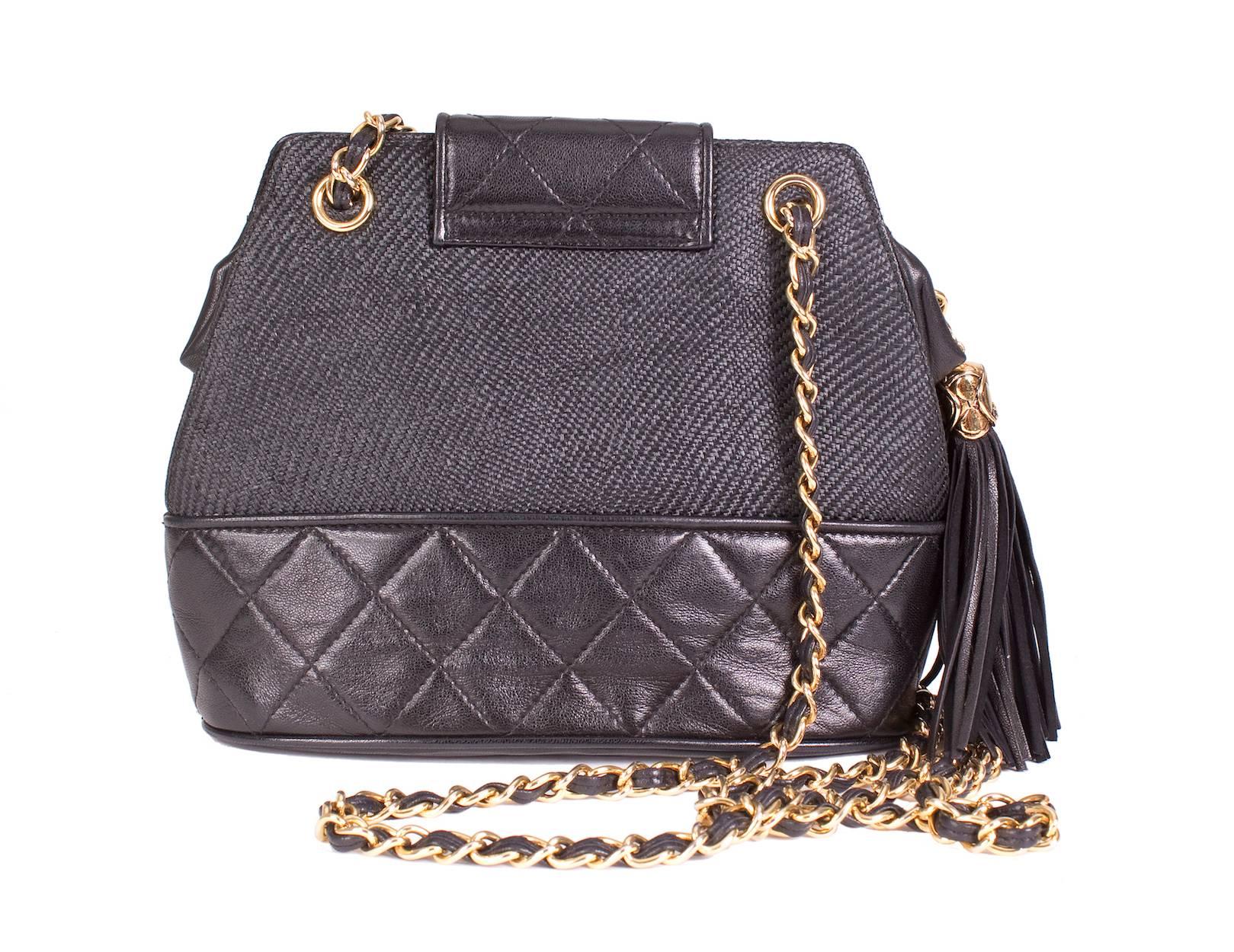 This is a quilted black leather and raffia shoulder bag by Chanel c. 1990.  It features a magnetic flap tab closure and an attached leather tassel.  It has one inside compartment with an inside zipper pocket.
9