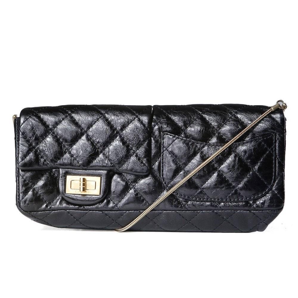This is a shoulder bag by Chanel from 2008.  It is made from quilted black leather and features two flap closures, one on each side.  Each flap has a gold hardware turn lock.  The bag also features a mirror on the inside of one of the flaps,