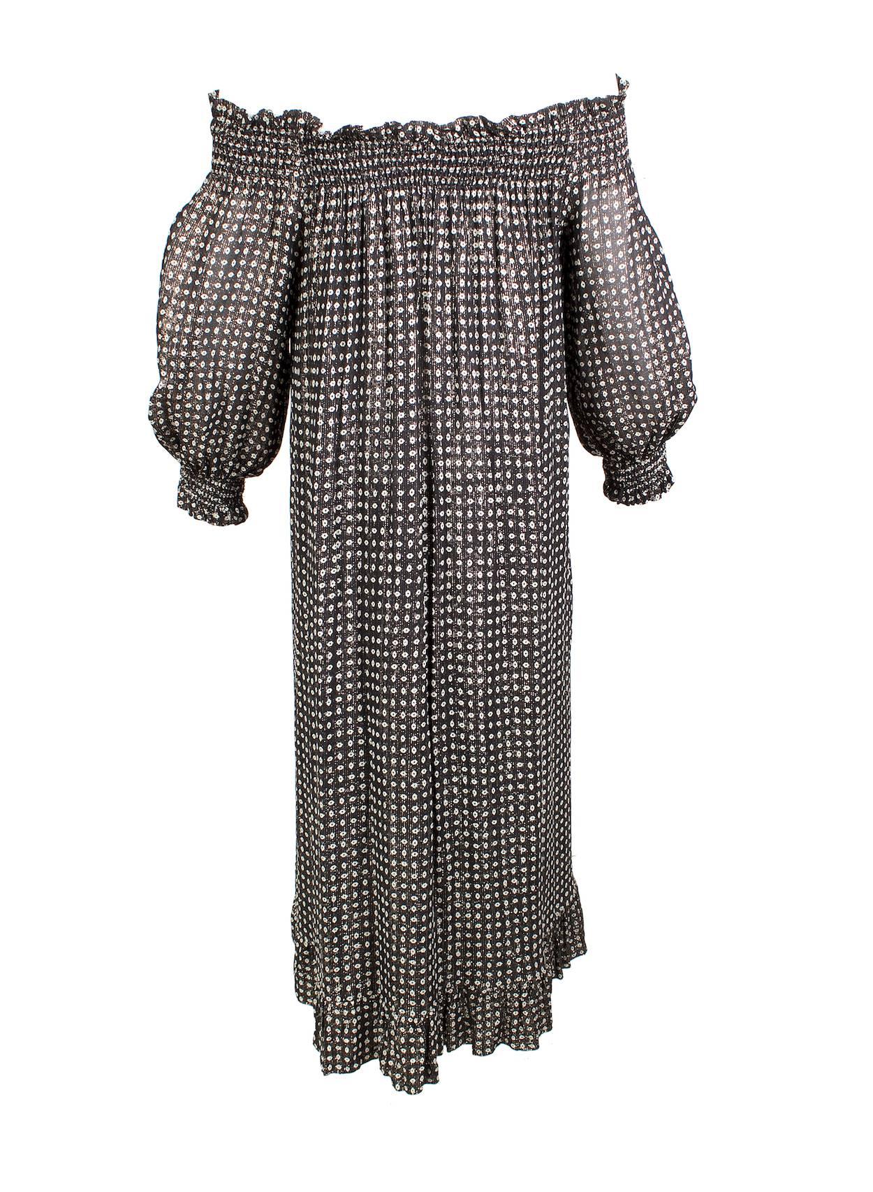 This is a tent dress by Givenchy c. 1970s.  It is made from black fabric with shimmering gold vertical threads and a small polka dot pattern.  It features a ribbed spandex ruffle collar and cuffs.  The dress can be worn off the shoulder or with a