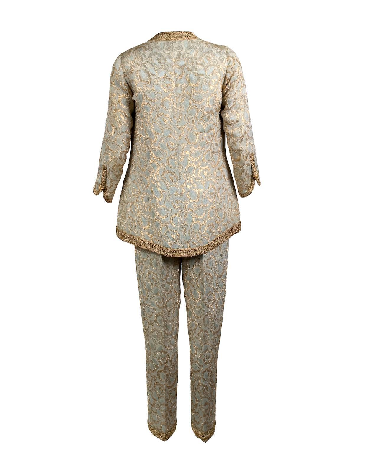 This is a pant suit by Chanel c. 1960s/70s  It is made from a baby blue and gold brocade fabric. It features a thick gold trim and has a matching baby blue satin lining.
13" shoulder to shoulder
20" sleeve length
Jacket bust is