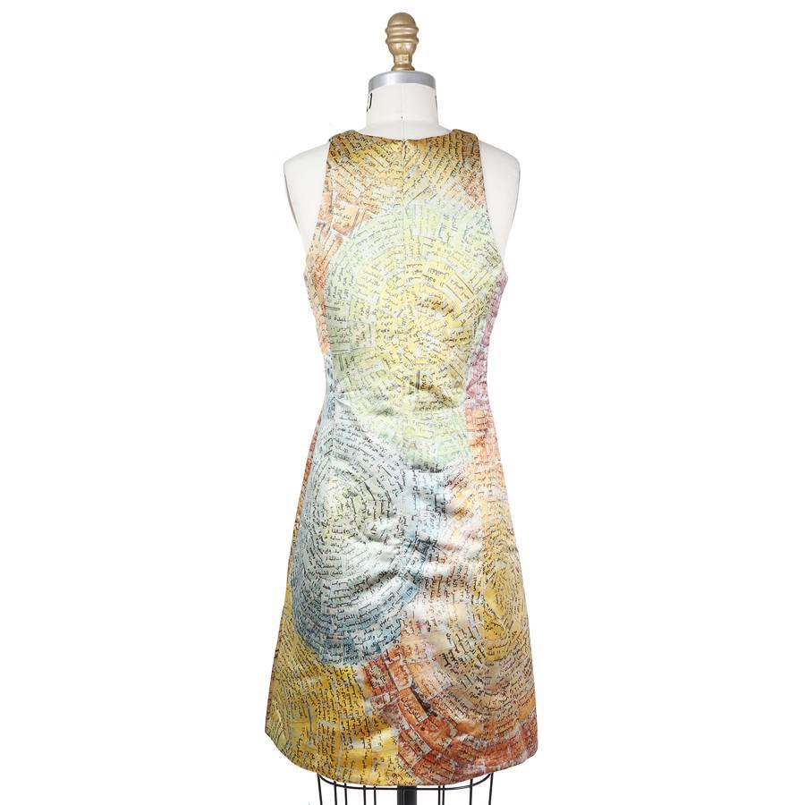 This is a sleeveless silk dress by Todd Oldham from 1997.  It has an A line cut with two dart seams down the front.  Faded multicolor circle motif with swirling Arabic text within the circles. The closure is a zipper down the back.