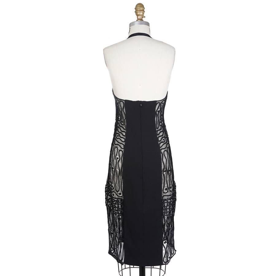 This is a little black dress by Todd Oldham from Spring 1996.  It features lace panels down each side.  The lace features a squiggling motif over a finer thread mesh to create a unique lace motif.  The halter strap is a spandex band.  The closure is