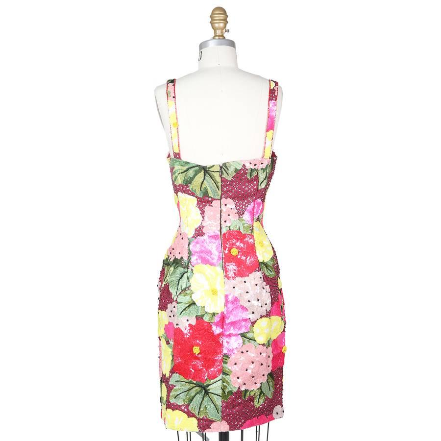 This is a sheath cut dress by Todd Oldham from spring 1992.  It features a large scale all over floral motif comprised of embroidery, sequins, and beads, including on the straps.  The closure is a hidden zipper down the center back.