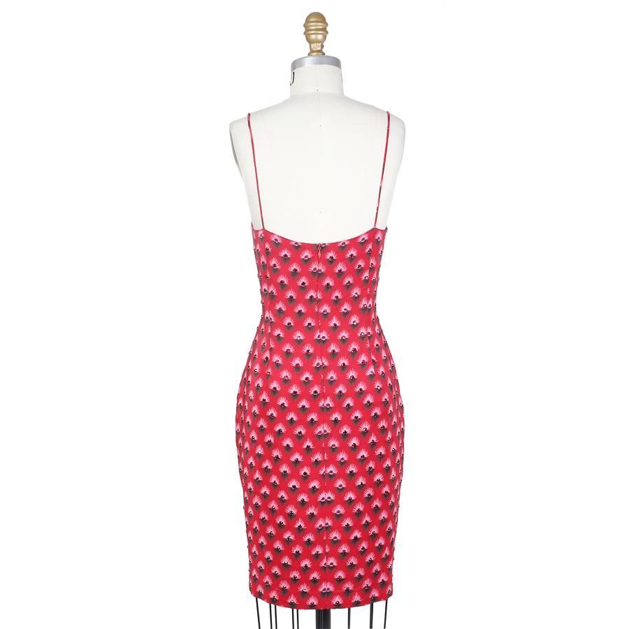 This is a sheath cut mini dress by Todd Oldham from fall 1992.  It is made of red silk that has a motif of printed eyelashes with a jewel iris.  The dress has spaghetti straps and the closure is an invisible zipper down the center back.
