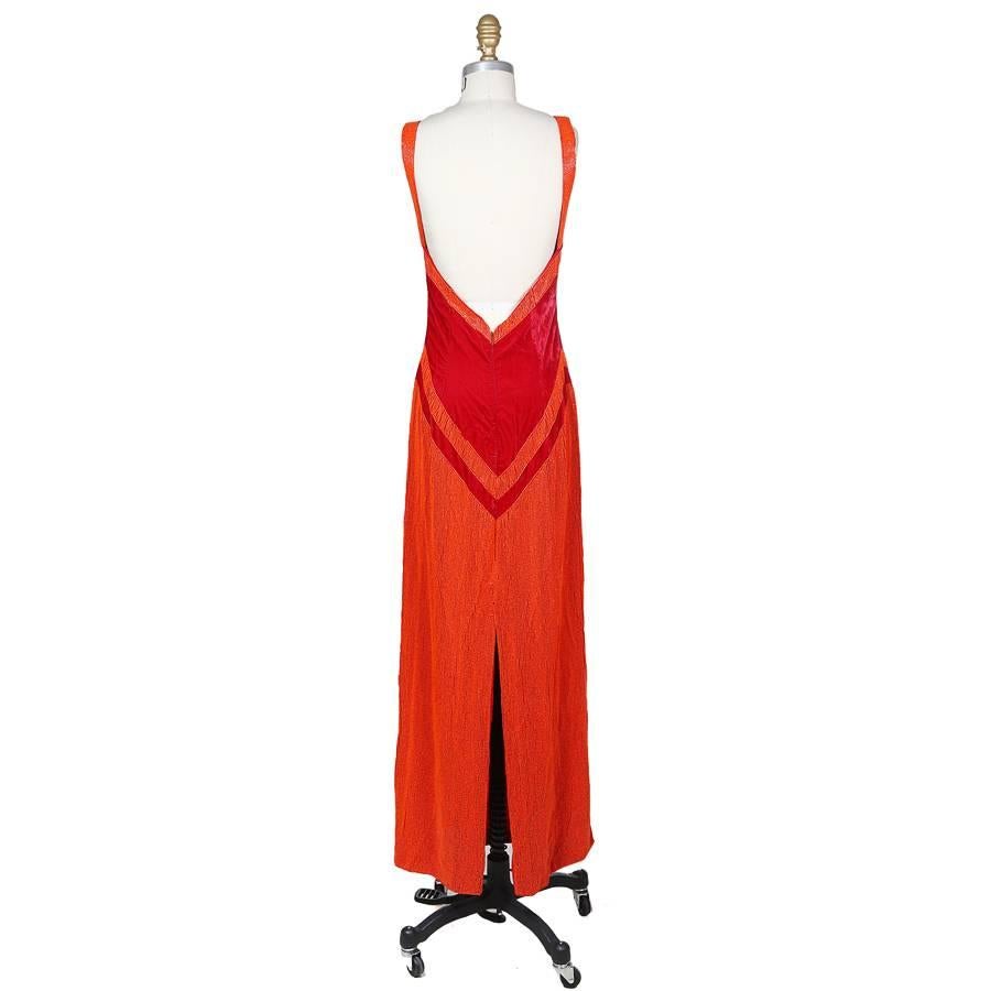 This is a dress by Todd Oldham from 1996.  It is made from red velvet and features orange beading in a zig zag motif.  It is lined in red satin, has 0.75" wide straps, and the closure is an invisible zipper down the back.  There is also a